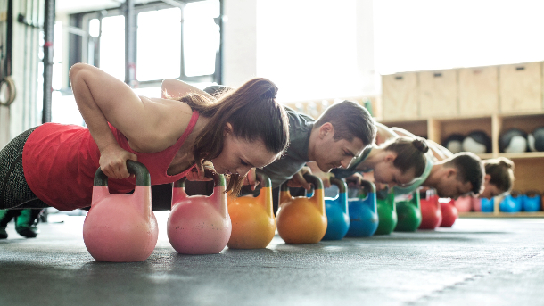 multi gender kettlebell class doing planks as part of their gym membership